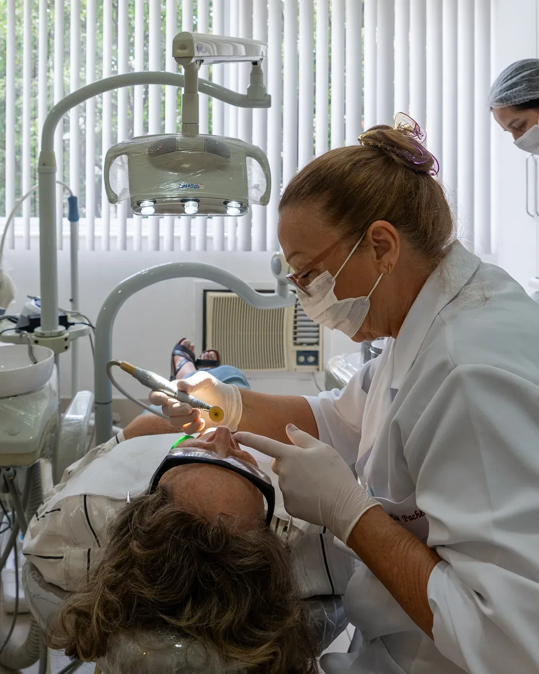 Atendimento odontológico na clínica Martino Pacheco, em Copacabana, com a Dra. Mariza durante um procedimento